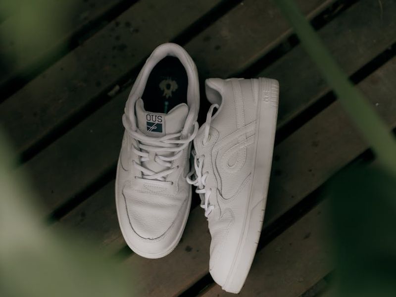 Detailed shot of athletic shoes and a clean wooden floor.